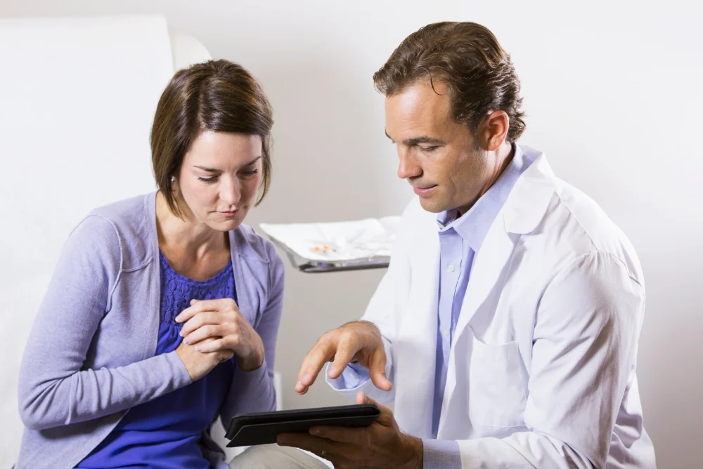 Audiologist with client showing details